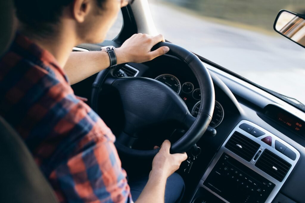 img 3496bfree 13861 Close-up view of a man driving a modern car, showing dashboard and steering details.